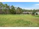 Expansive green field with scattered trees and a glimpse of nearby houses provides a serene setting at 1669 Beleek Ridge Ln, Clover, SC 29710