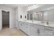 Bright bathroom featuring a double vanity, large mirror, and a glass-enclosed shower at 18013 Aura Mist Way # 183, Huntersville, NC 28078