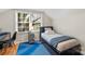 Bright bedroom featuring paneled walls, a bed by the window, and blue patterned carpet at 206 23Rd Nw St, Hickory, NC 28601