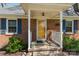 Close-up of a charming front porch with yellow door, brick exterior, and flower accents at 206 23Rd Nw St, Hickory, NC 28601