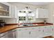 Charming kitchen boasts white cabinets, wood countertops, stainless sink, and natural light from the window at 206 23Rd Nw St, Hickory, NC 28601