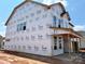 New construction home with Tyvek wrap features a covered patio and large windows with a blue sky at 2212 Indigo Branch Rd, Indian Land, SC 29707