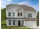 Two-story home featuring stone accents, a two-car garage and welcoming front porch at 2212 Indigo Branch Rd, Indian Land, SC 29707