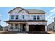 New construction home features a two-car garage and large windows, covered in Tyvek wrap at 2212 Indigo Branch Rd, Indian Land, SC 29707