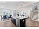 Open concept kitchen with a large island, farmhouse sink, stainless appliances, and views to living and dining area at 2212 Indigo Branch Rd, Indian Land, SC 29707