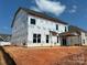 Wide angle view of the back of new construction home with covered patio under a bright sky at 2212 Indigo Branch Rd, Indian Land, SC 29707