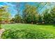 Lush green backyard featuring a pristine lawn and a variety of trees for a serene outdoor space at 2610 Mchanna Pt, Fort Mill, SC 29708