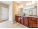 Elegant bathroom with double sink granite vanity, cherry wood cabinets, and tiled floors at 2610 Mchanna Pt, Fort Mill, SC 29708