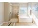 Bright bathroom features a glass shower and a large soaking tub next to a window at 2610 Mchanna Pt, Fort Mill, SC 29708