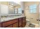 Bright bathroom featuring a granite countertop, double sinks, a mirror, and a window at 2610 Mchanna Pt, Fort Mill, SC 29708