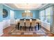Elegant dining room featuring a chandelier, tray ceiling, and ample natural light from large windows at 2610 Mchanna Pt, Fort Mill, SC 29708