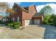 The side of the home features a three-car garage and manicured landscaping, adding to its charm at 2610 Mchanna Pt, Fort Mill, SC 29708