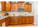 Stylish kitchen featuring stainless steel microwave and cooktop, granite countertops, and wooden cabinets at 2610 Mchanna Pt, Fort Mill, SC 29708