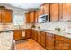 Modern kitchen featuring stainless steel cooktop, microwave, granite countertops, and wooden cabinets at 2610 Mchanna Pt, Fort Mill, SC 29708