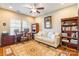 Well-lit office space with a ceiling fan, bookshelves, and a comfortable sofa for relaxation at 2610 Mchanna Pt, Fort Mill, SC 29708