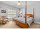 Cozy bedroom featuring a wooden four-poster bed, neutral walls, and a comfy accent chair at 2731 Laugenour Pl, Kannapolis, NC 28081