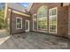 Exterior featuring patio with brick house, large windows, and lush surrounding greenery at 2731 Laugenour Pl, Kannapolis, NC 28081