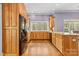 Open kitchen with stainless steel appliances, wood cabinets, granite counters, and natural light at 2731 Laugenour Pl, Kannapolis, NC 28081