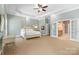 Spacious main bedroom featuring tray ceilings, a ceiling fan, and access to the ensuite bathroom at 2731 Laugenour Pl, Kannapolis, NC 28081