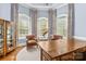 Bright office space with large windows, plush seating, and a wooden desk, perfect for a home workspace at 2731 Laugenour Pl, Kannapolis, NC 28081