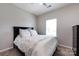 Bedroom featuring a queen-sized bed, soft lighting, and a window with blinds at 325 Crandon Rd, Mount Holly, NC 28120