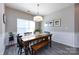 Bright dining area featuring a wood table with bench seating and three framed prints on the wall at 325 Crandon Rd, Mount Holly, NC 28120