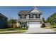 Charming two-story home with a covered front porch, attached two-car garage, and manicured landscaping at 325 Crandon Rd, Mount Holly, NC 28120