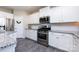 Modern kitchen showcases white cabinets, stainless steel appliances, and granite countertops with a white backsplash at 325 Crandon Rd, Mount Holly, NC 28120
