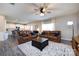 Open concept living area with tan leather furniture, ceiling fan, and natural light at 325 Crandon Rd, Mount Holly, NC 28120