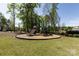The community playground is nestled among mature trees in a grassy area at 325 Crandon Rd, Mount Holly, NC 28120