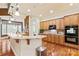 Open kitchen featuring an island with granite countertops, wooden cabinets, and modern appliances at 331 Miners Cove Way, Fort Mill, SC 29708