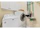 Functional laundry room with washer, dryer, and overhead cabinets at 331 Miners Cove Way, Fort Mill, SC 29708