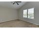 This bedroom has a vaulted ceiling and a large window letting in natural light and neutral walls at 3835 Mohawk Ct, Charlotte, NC 28215