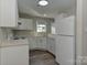 Well-lit kitchen with white cabinets, laminate countertops, modern appliances, and wood-look floors at 3835 Mohawk Ct, Charlotte, NC 28215