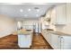 Open kitchen with island, stainless appliances, granite countertops, and sleek, continuous hardwood floors at 4006 Fall Oak Ter, Fort Mill, SC 29707