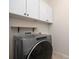 Bright laundry room with a modern gray Whirlpool washer and white cabinets at 4006 Fall Oak Ter, Fort Mill, SC 29707
