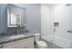 Modern bathroom featuring granite counters, a sleek mirror, and a glass-enclosed shower and tub at 406 Williamson St, Fort Mill, SC 29715