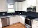 Modern kitchen featuring stainless steel appliances, granite counters, and sleek, dark backsplash at 406 Williamson St, Fort Mill, SC 29715