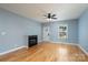Bright living room with hardwood floors, a decorative fireplace, and a ceiling fan, creating a cozy atmosphere at 406 Williamson St, Fort Mill, SC 29715