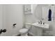 Bright half bathroom with a pedestal sink, toilet, and decorative mirror at 4120 Spring Cove Way, Belmont, NC 28012