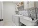 Well-lit laundry room featuring a washer, dryer, utility sink, decorative backsplash, and ample storage at 4120 Spring Cove Way, Belmont, NC 28012