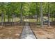 Lakeside property features a stone path leading to a private dock with scenic views and tranquil waterfront access at 4120 Spring Cove Way, Belmont, NC 28012