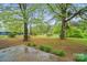 Spacious backyard with lush greenery, mature trees, and a view of the surrounding nature at 422 Sherrill Farm Rd, Lincolnton, NC 28092