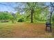 View of a spacious backyard with mature trees, grill, and lush greenery at 422 Sherrill Farm Rd, Lincolnton, NC 28092