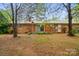 Exterior shot of a brick ranch home with mature trees, a birdhouse, and a patio at 422 Sherrill Farm Rd, Lincolnton, NC 28092