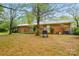 The backyard features mature trees, lawn, birdhouse, patio, and a grill at 422 Sherrill Farm Rd, Lincolnton, NC 28092