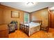 Inviting bedroom featuring wood paneling, carpet, with a comfortable bed and ample natural light at 422 Sherrill Farm Rd, Lincolnton, NC 28092