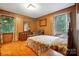 Cozy bedroom with wood paneling, carpet, dresser, and natural light from windows with floral curtains at 422 Sherrill Farm Rd, Lincolnton, NC 28092