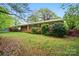 Charming one-story brick home featuring a lush green lawn, mature trees, and colorful shrubs at 422 Sherrill Farm Rd, Lincolnton, NC 28092