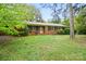 Charming brick home featuring a well-maintained lawn, mature trees, and colorful flowering bushes for a welcoming curb appeal at 422 Sherrill Farm Rd, Lincolnton, NC 28092